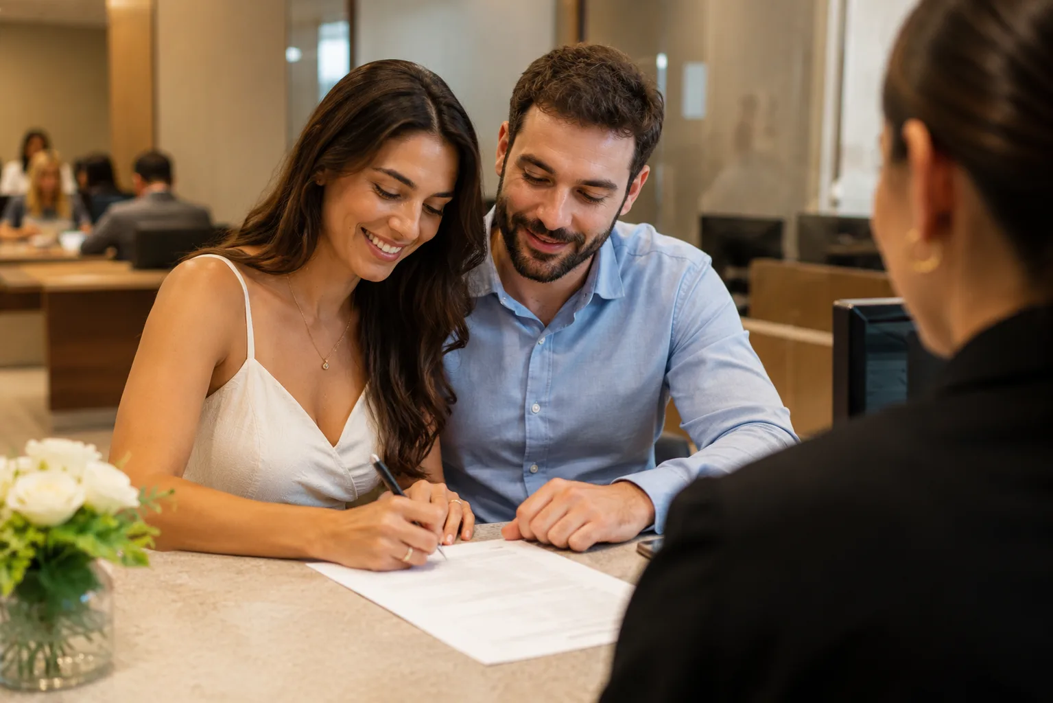 Casal assinando documento no balcão do cartório de registro civil